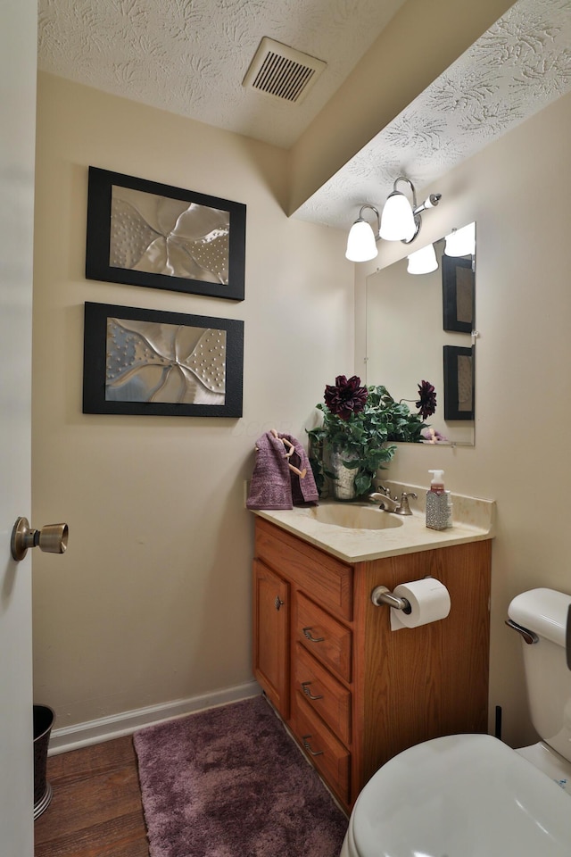 2214-2216 Pine Tree Ln, Reynoldsburg, OH 43068 - half bathroom featuring vanity, a textured ceiling, and wood finished floors