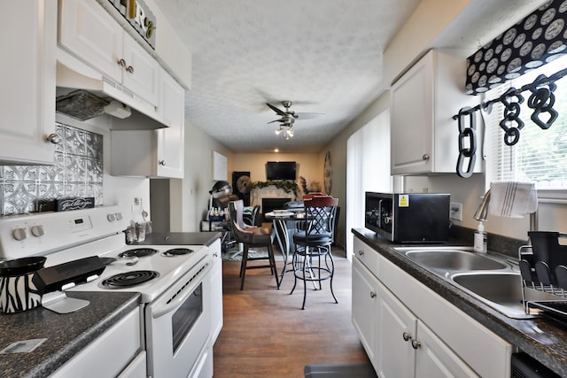 2214-2216 Pine Tree Ln, Reynoldsburg, OH 43068 - kitchen with white range with electric cooktop, stainless steel microwave, dark countertops, a ceiling fan, and a textured ceiling
