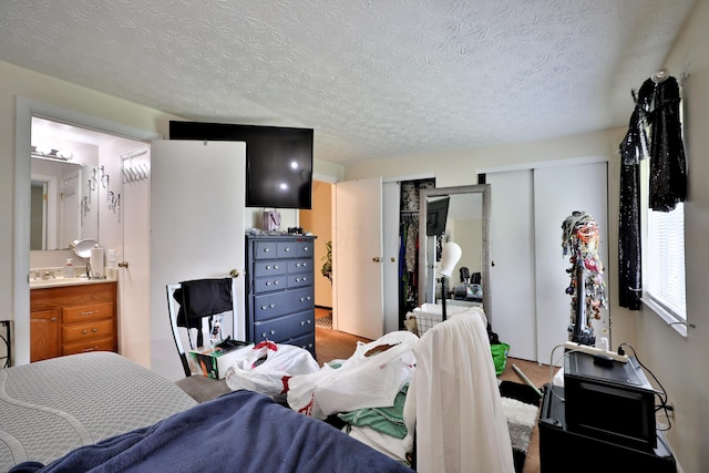 2214-2216 Pine Tree Ln, Reynoldsburg, OH 43068 - carpeted bedroom featuring multiple closets, a textured ceiling, and ensuite bathroom