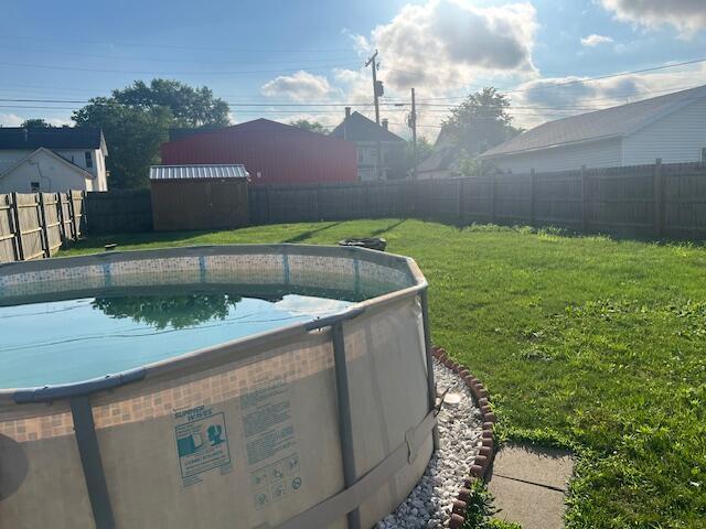427 John St, Newark, OH 43055 - view of swimming pool featuring a fenced backyard and a storage shed