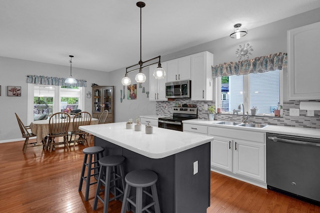 307 Timberland View Dr, Newark, OH 43055 - kitchen featuring appliances with stainless steel finishes, backsplash, hardwood / wood-style floors, a breakfast bar, and white cabinetry