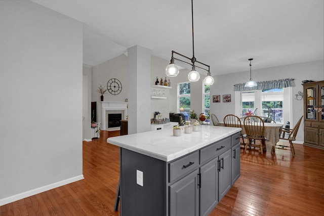 307 Timberland View Dr, Newark, OH 43055 - kitchen featuring gray cabinets, hardwood / wood-style floors, a kitchen island, hanging light fixtures, and a fireplace