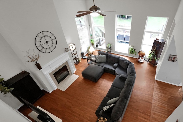 307 Timberland View Dr, Newark, OH 43055 - living area featuring a high ceiling, wood finished floors, a tiled fireplace, and a ceiling fan