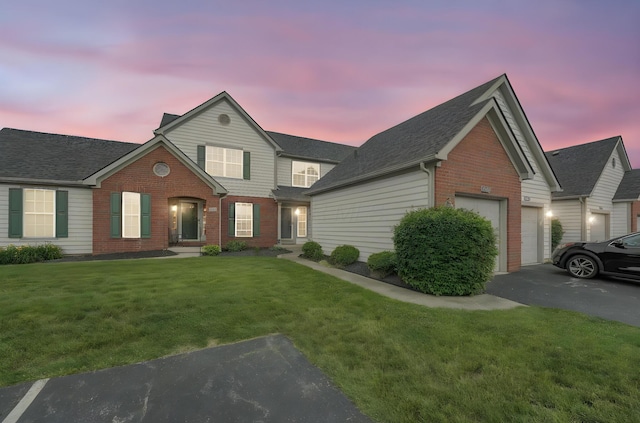 2184 Victoria Park Dr, Columbus, OH 43235 - traditional-style house with brick siding, a garage, asphalt driveway, a yard, and roof with shingles
