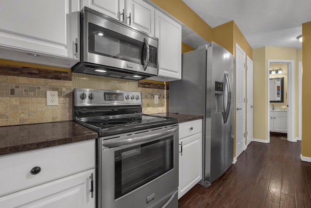 2184 Victoria Park Dr, Columbus, OH 43235 - kitchen featuring appliances with stainless steel finishes, white cabinets, dark wood-type flooring, and decorative backsplash