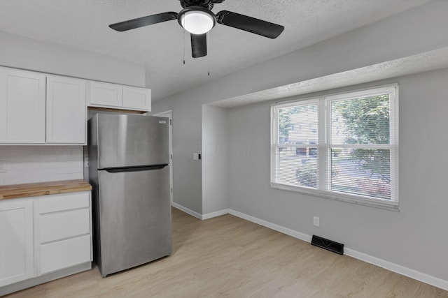 1615 Coronet Dr, Columbus, OH 43224 - kitchen featuring freestanding refrigerator, wood counters, white cabinetry, light wood-style floors, and decorative backsplash