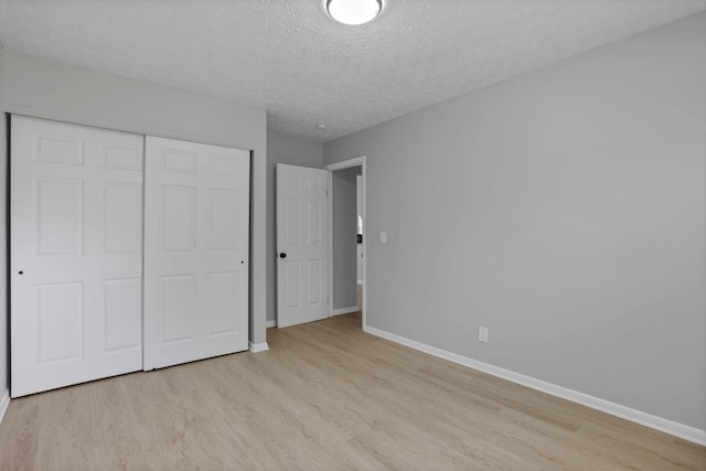 1615 Coronet Dr, Columbus, OH 43224 - unfurnished bedroom featuring light wood-style floors, a closet, and a textured ceiling