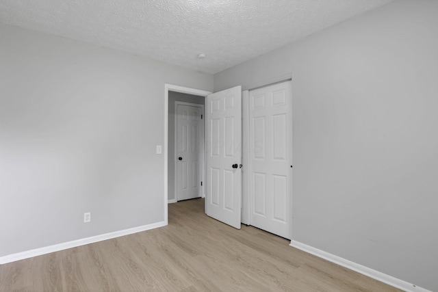 1615 Coronet Dr, Columbus, OH 43224 - unfurnished bedroom featuring light wood-style floors, a textured ceiling, and a closet