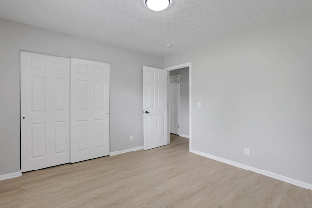 1615 Coronet Dr, Columbus, OH 43224 - unfurnished bedroom with light wood-type flooring, a textured ceiling, and a closet
