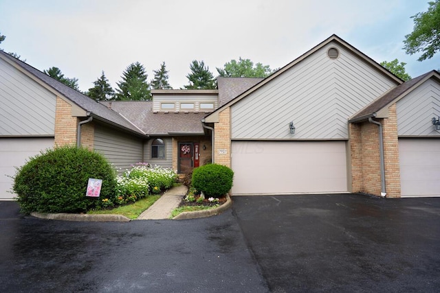 7937 Clark Ave Unit 38, Dublin, OH 43017 - mid-century modern home with an attached garage, asphalt driveway, brick siding, and roof with shingles