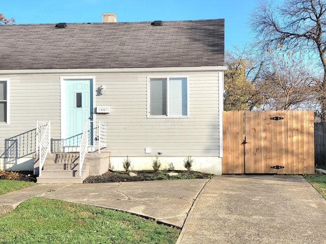 570 N Ohio Ave, Columbus, OH 43203 - view of front of home featuring a gate, roof with shingles, and a chimney