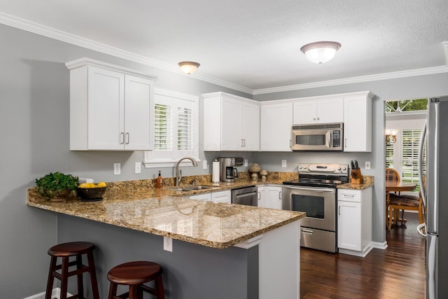 918 Dianthus Ct, Reynoldsburg, OH 43068 - kitchen with stainless steel appliances, a peninsula, light stone countertops, healthy amount of natural light, and ornamental molding