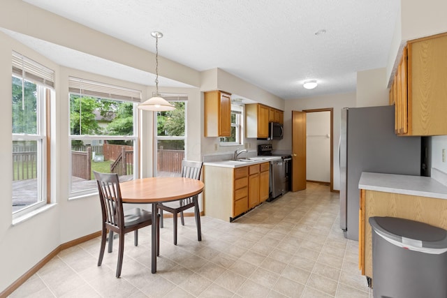 3299 Bellowind Dr, Reynoldsburg, OH 43068 - kitchen with stainless steel appliances, light countertops, a textured ceiling, and decorative light fixtures