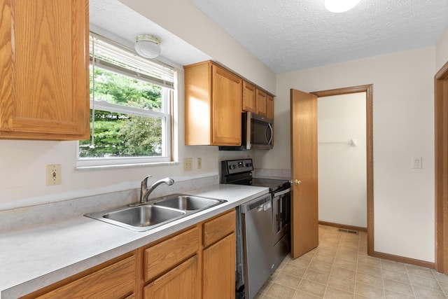 3299 Bellowind Dr, Reynoldsburg, OH 43068 - kitchen with stainless steel appliances, light countertops, a textured ceiling, and brown cabinetry