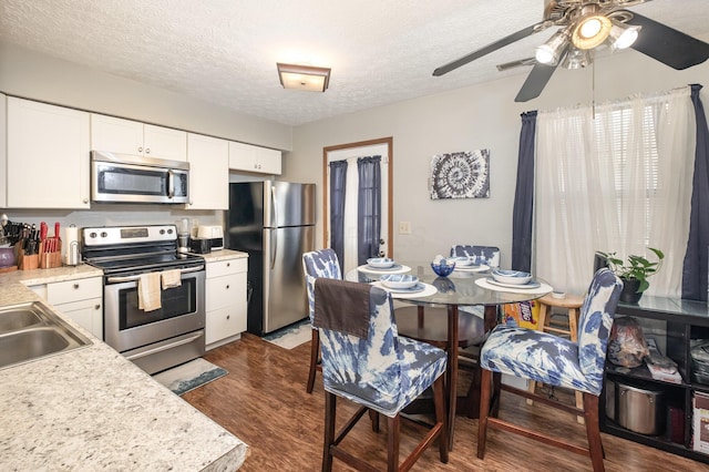 2939 Arrowsmith Dr, Reynoldsburg, OH 43068 - kitchen featuring stainless steel appliances, light countertops, a ceiling fan, dark wood-style floors, and a textured ceiling