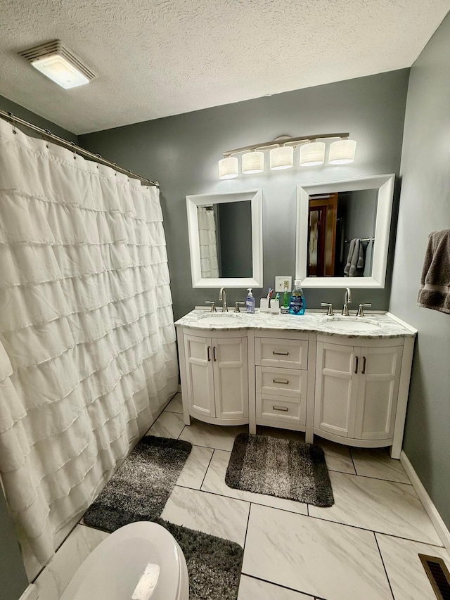 630 Duffy Dr, Washington Court House, OH 43160 - full bath featuring double vanity, marble finish flooring, a textured ceiling, and a shower with shower curtain
