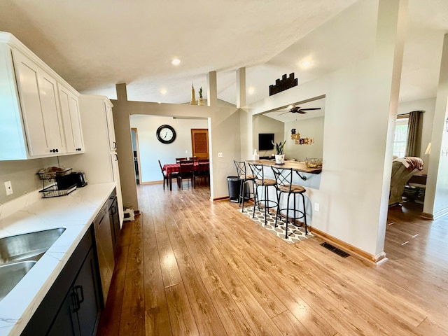 630 Duffy Dr, Washington Court House, OH 43160 - kitchen with wood-type flooring, white cabinetry, lofted ceiling, a ceiling fan, and recessed lighting