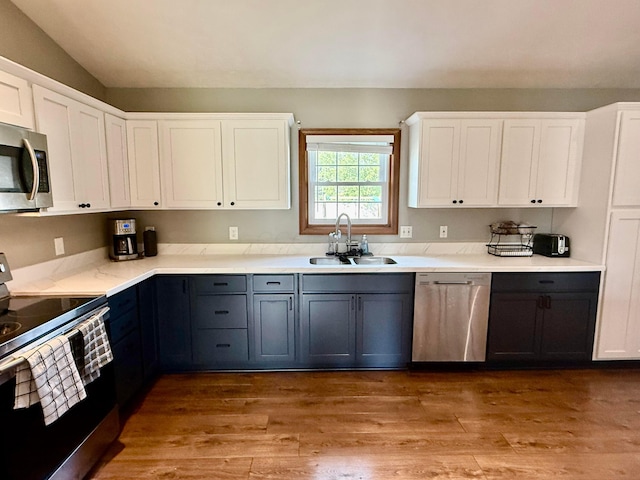 630 Duffy Dr, Washington Court House, OH 43160 - kitchen featuring appliances with stainless steel finishes, white cabinets, light wood finished floors, vaulted ceiling, and gray cabinetry