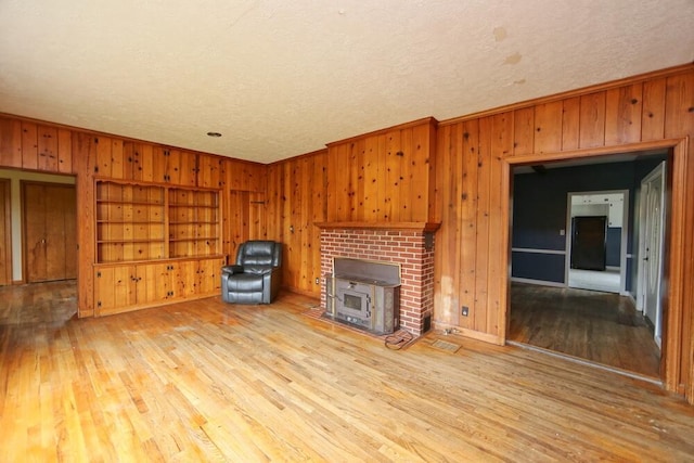 7579 Rangeline Rd, Mount Vernon, OH 43050 - unfurnished living room with light wood-style floors, a textured ceiling, wood walls, and crown molding