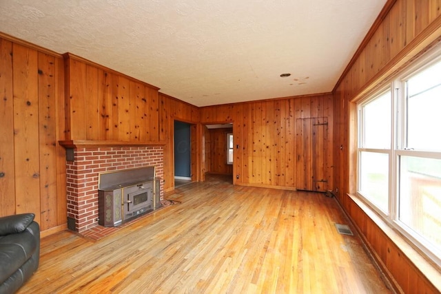 7579 Rangeline Rd, Mount Vernon, OH 43050 - unfurnished living room with wooden walls, plenty of natural light, light wood finished floors, crown molding, and a fireplace