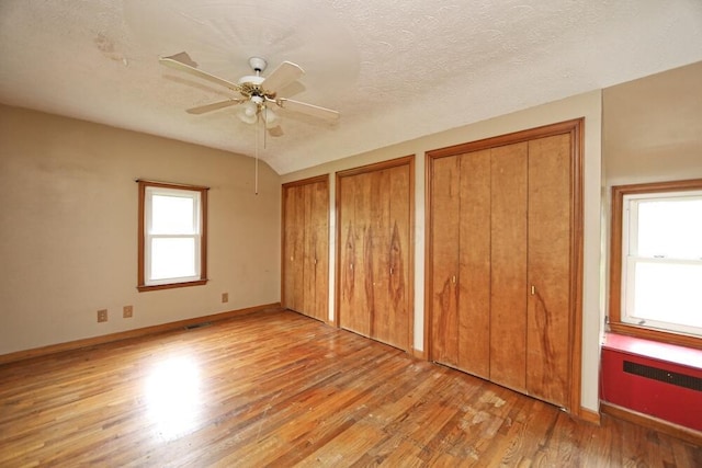 7579 Rangeline Rd, Mount Vernon, OH 43050 - unfurnished bedroom with light wood-type flooring, multiple closets, a ceiling fan, and a textured ceiling