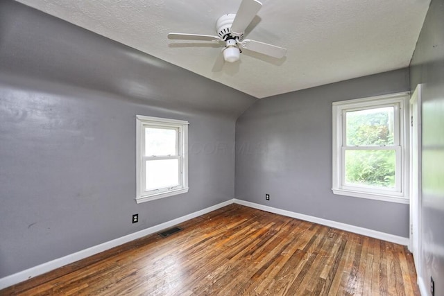 7579 Rangeline Rd, Mount Vernon, OH 43050 - unfurnished room with wood-type flooring, lofted ceiling, a ceiling fan, and a textured ceiling