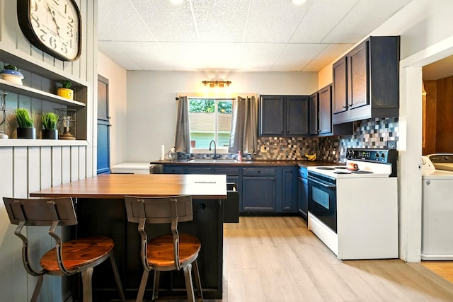 78 E St, Bellville, OH 44813 - kitchen featuring white electric range, light wood-style flooring, a breakfast bar, and washer and clothes dryer