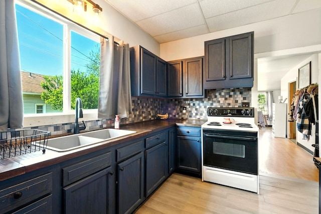 78 E St, Bellville, OH 44813 - kitchen featuring electric range oven, a paneled ceiling, backsplash, light wood-style flooring, and tile countertops