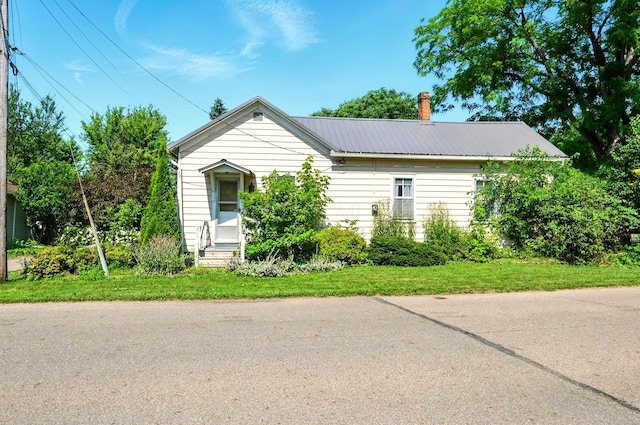 78 E St, Bellville, OH 44813 - view of front of home with entry steps, a metal roof, and a chimney
