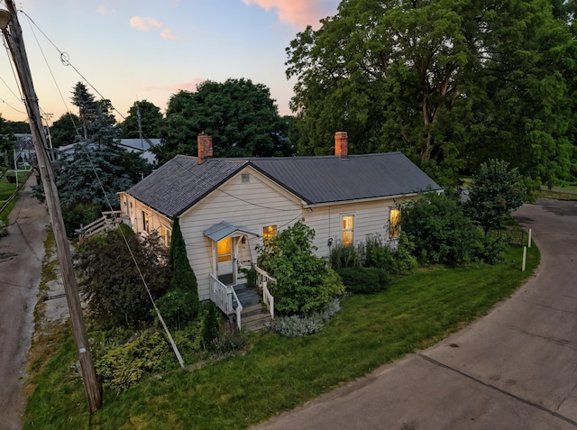 78 E St, Bellville, OH 44813 - bungalow-style house featuring a chimney, a yard, and a metal roof