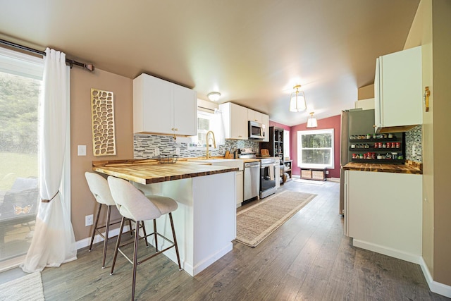 13399 Staddens Bridge Rd SE, Heath, OH 43056 - kitchen with stainless steel appliances, wooden counters, decorative backsplash, wood finished floors, and lofted ceiling