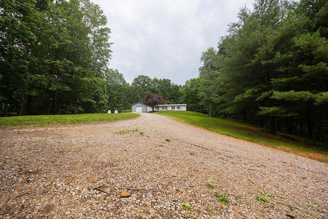 13399 Staddens Bridge Rd SE, Heath, OH 43056 - view of front of property with an outbuilding, a forest view, driveway, a garage, and a front yard