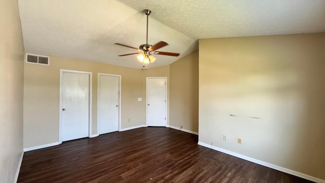 7831 Fairfax Loop Dr, Blacklick, OH 43004 - unfurnished bedroom featuring dark wood-style flooring, lofted ceiling, a textured ceiling, multiple closets, and a ceiling fan