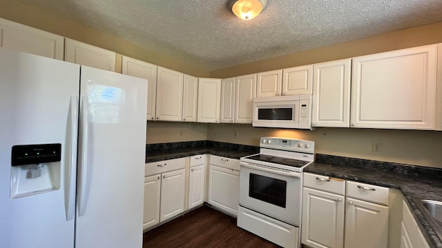 7831 Fairfax Loop Dr, Blacklick, OH 43004 - kitchen featuring white appliances, dark wood finished floors, dark countertops, white cabinets, and a textured ceiling