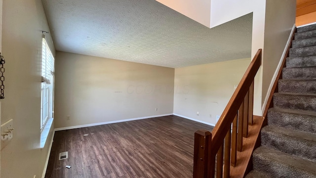 7831 Fairfax Loop Dr, Blacklick, OH 43004 - empty room featuring dark wood finished floors, stairway, and a textured ceiling