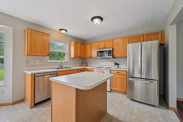 1016 Pebble Brook Dr, Columbus, OH 43240 - kitchen featuring appliances with stainless steel finishes, light countertops, a kitchen island, and a textured ceiling