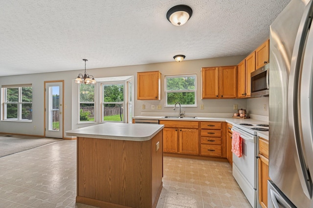 1016 Pebble Brook Dr, Columbus, OH 43240 - kitchen featuring stainless steel appliances, light countertops, a chandelier, a center island, and decorative light fixtures