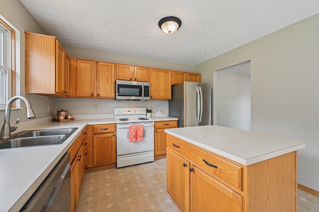 1016 Pebble Brook Dr, Columbus, OH 43240 - kitchen featuring stainless steel appliances, light countertops, light floors, a textured ceiling, and a kitchen island