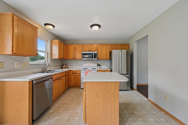 1016 Pebble Brook Dr, Columbus, OH 43240 - kitchen with appliances with stainless steel finishes, a center island, light countertops, light flooring, and a textured ceiling