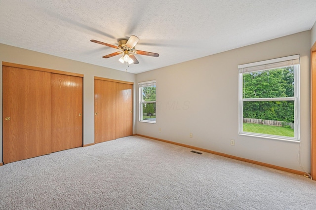 1016 Pebble Brook Dr, Columbus, OH 43240 - unfurnished bedroom featuring multiple closets, carpet, a textured ceiling, and ceiling fan