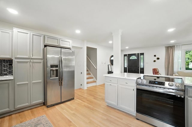 2820 Halstead Rd, Columbus, OH 43221 - kitchen with stainless steel appliances, light wood-style flooring, light countertops, recessed lighting, and ornate columns
