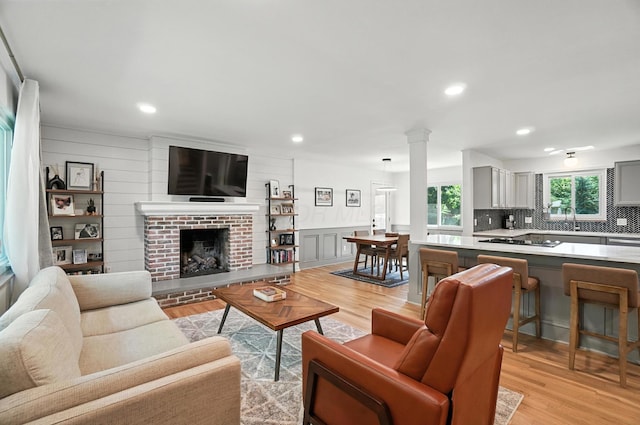2820 Halstead Rd, Columbus, OH 43221 - living area featuring light wood-type flooring, recessed lighting, a fireplace, ornate columns, and wainscoting
