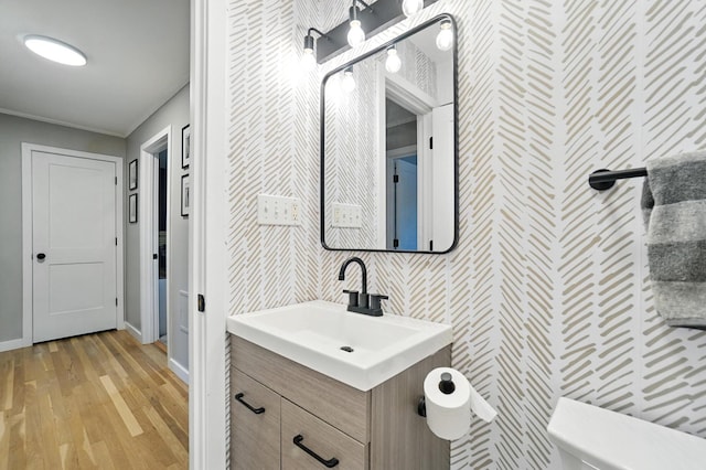 2820 Halstead Rd, Columbus, OH 43221 - bathroom with vanity, wood finished floors, ornamental molding, and wallpapered walls