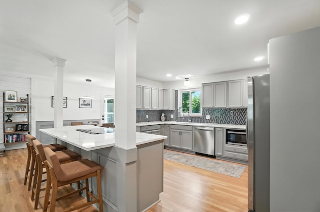 2820 Halstead Rd, Columbus, OH 43221 - kitchen with appliances with stainless steel finishes, ornate columns, gray cabinetry, light wood-type flooring, and recessed lighting