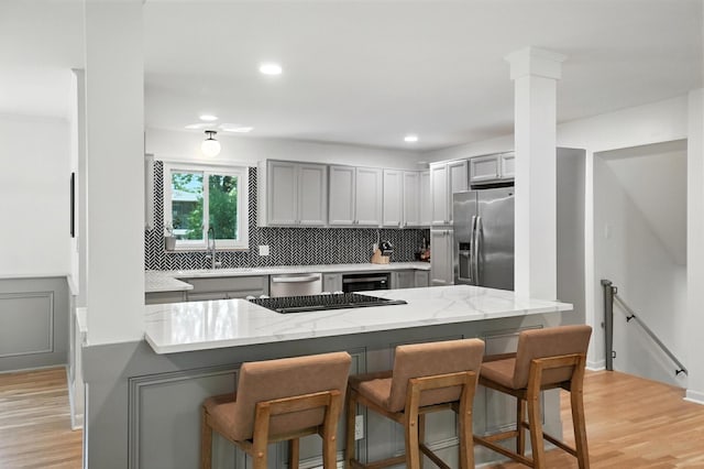 2820 Halstead Rd, Columbus, OH 43221 - kitchen featuring stainless steel appliances, gray cabinets, a kitchen breakfast bar, decorative backsplash, and recessed lighting