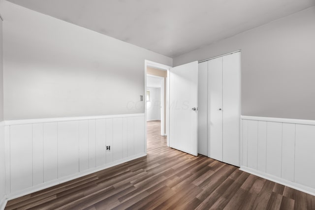 3505 Roswell Dr, Columbus, OH 43227 - unfurnished bedroom featuring dark wood-style floors, a wainscoted wall, and a closet