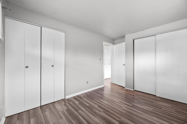 3505 Roswell Dr, Columbus, OH 43227 - unfurnished bedroom with wood finished floors, multiple closets, and crown molding