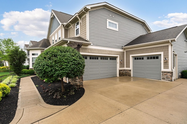 6196 Streamside Dr, Galena, OH 43021 - view of side of home with concrete driveway, stone siding, roof with shingles, and board and batten siding