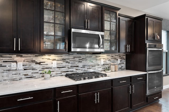 6196 Streamside Dr, Galena, OH 43021 - kitchen with stainless steel appliances, dark wood-type flooring, decorative backsplash, glass insert cabinets, and dark brown cabinets
