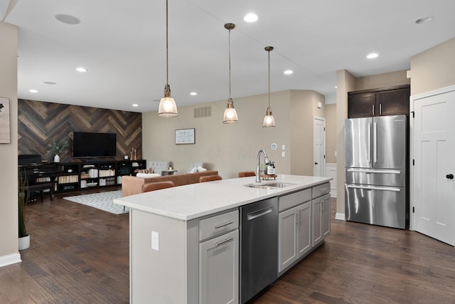 6196 Streamside Dr, Galena, OH 43021 - kitchen with appliances with stainless steel finishes, open floor plan, an accent wall, dark wood-type flooring, and decorative light fixtures